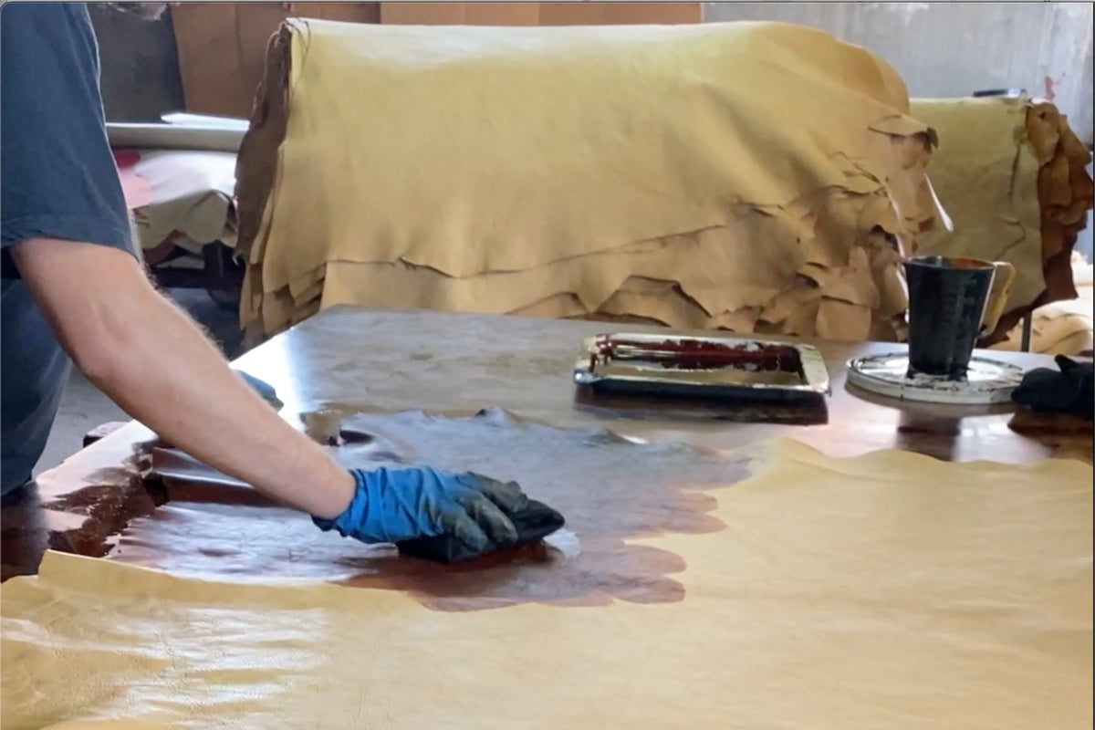 Paolo's hands working dye into a vegetable-tanned hide at our tannery in Tuscany
